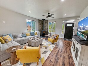 Una sala moderna con sofá, sillones, una mesita de centro y chimenea.