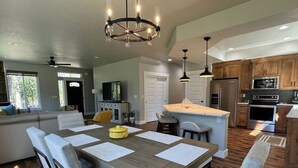 A spacious kitchen with wooden cabinets, a central island, and modern appliances. - Stunning Home Close to Lake Cascade (Donnelly)