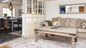 A living room with a wooden coffee table, beige sofa, and a decorative screen. - 4 Person Holiday Home in Skaerbaek (Skaerbaek)