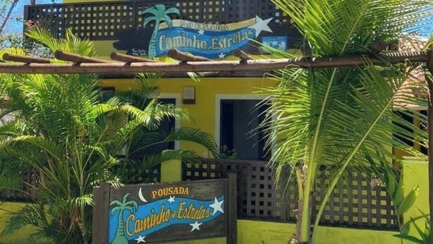 A building with a sign reading "Pousada Caninho Estrela" and a wooden fence. - Pousada Caminho das Estrelas (Mata de São João)