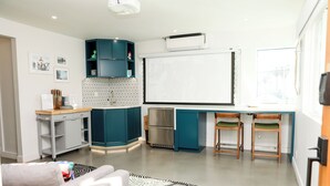 A compact kitchen with teal cabinets, a built-in oven, and a large window. - The Escape - Suite 4 (Venice)