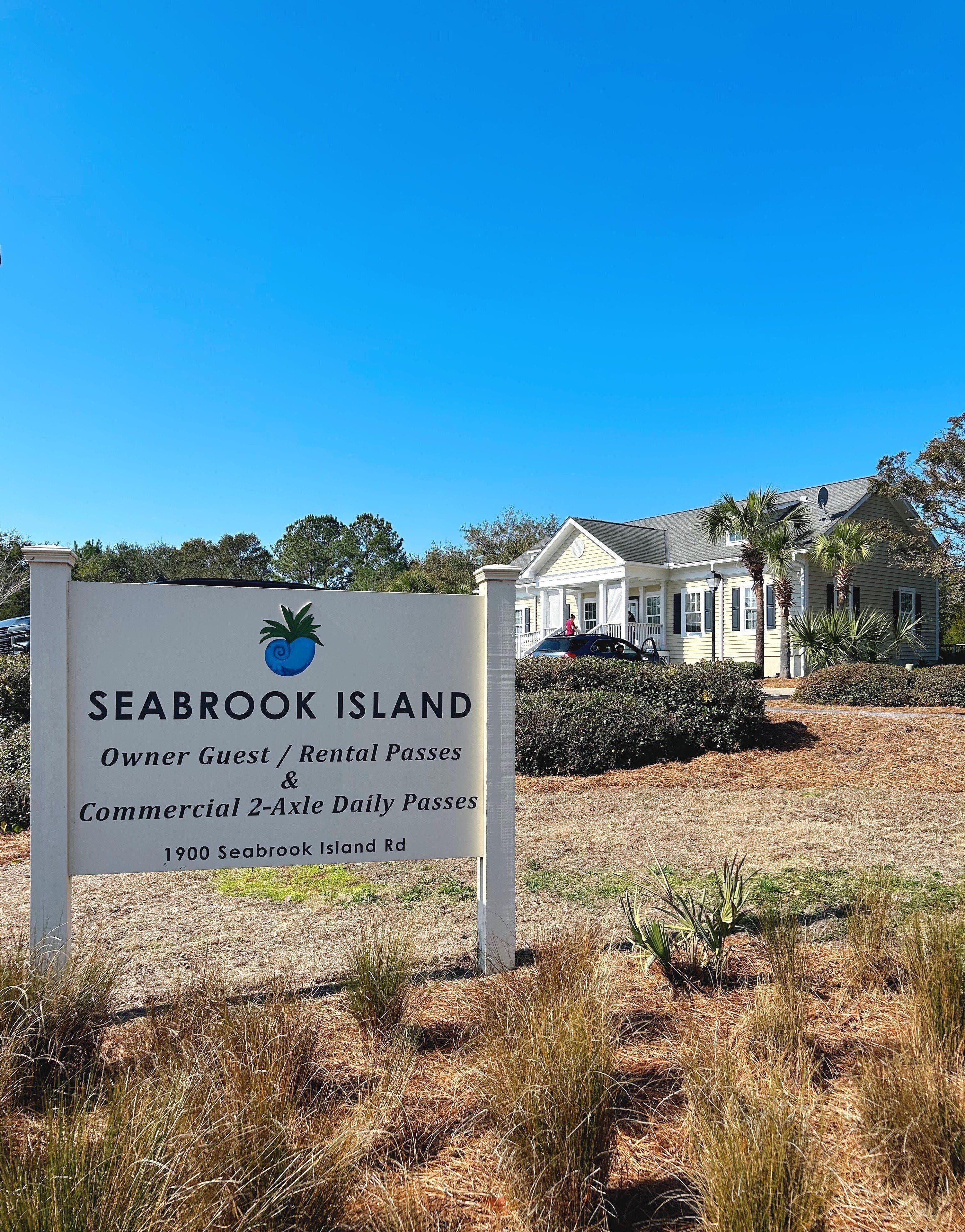 A sign for Seabrook Island with a two-story house in the background.