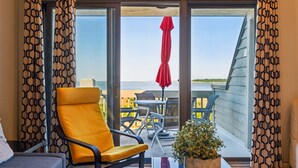 Une pièce avec une chaise jaune, une petite table et une plante en pot.