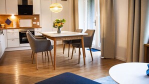A modern kitchen with white cabinets, a built-in oven, and a hanging light fixture. - Small House Lake Modern Retreat (Feldberger Seenlandschaft)