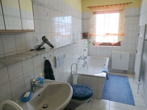 A bathroom with a sink, mirror, towel rack, and a window with curtains. - Daumler "house Am Weisswald" (Breitenbrunn/Erzgeb.)