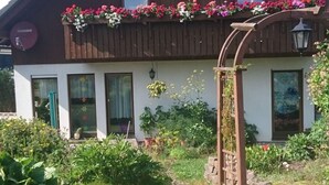 A house with a garden in front, a wooden fence, and a stone wall. - Daumler "house Am Weisswald" (Breitenbrunn/Erzgeb.)