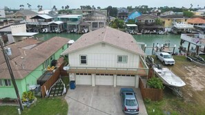 A residential area with a house featuring a garage, a driveway, and a boat dock.