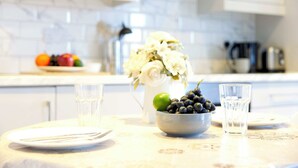 Eine Küchenarbeitsplatte mit einer Obstschale, einem Blumenstrauß und zwei Wassergläsern.