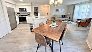 A modern kitchen with white cabinetry, a central island, and stainless steel appliances.