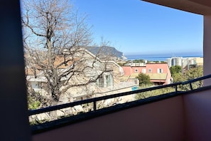 A balcony with a view of buildings and a coastline.