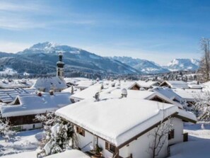 A snow-covered village with traditional houses and a church. - Berggluck Comfortable Holiday Residence (Reit im Winkl)
