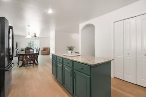 Una cocina con comedor, armarios de madera y una puerta blanca.