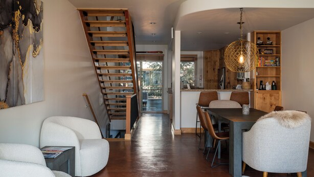 Un interno moderno con una scala, un'area pranzo e una cucina.
