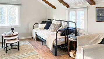 A bedroom with a bed, bedside tables, a chair, and a window.