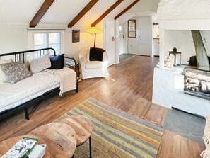 Un salon chaleureux avec un canapé, un fauteuil et une petite table agrémentée d’objets décoratifs.
