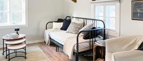 A bedroom with a bed, bedside tables, a chair, and a window.