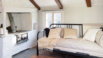 A cozy room with a bed, a fireplace, and a window.