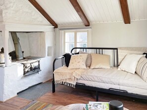 A cozy room with a bed, a fireplace, and a window. - 4 Person Holiday Home in Farjestaden (Farjestaden)