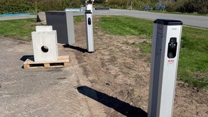 Un área de estacionamiento con barreras de concreto y un letrero que indica un espacio para estacionar.