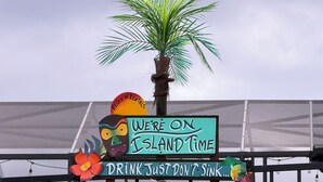 A colorful sign with various phrases and a palm tree. - Relax N Rentals Waterfront 4BR 2BA Port Charlotte FL Pool Kayaks Harbor Access (Port Charlotte)