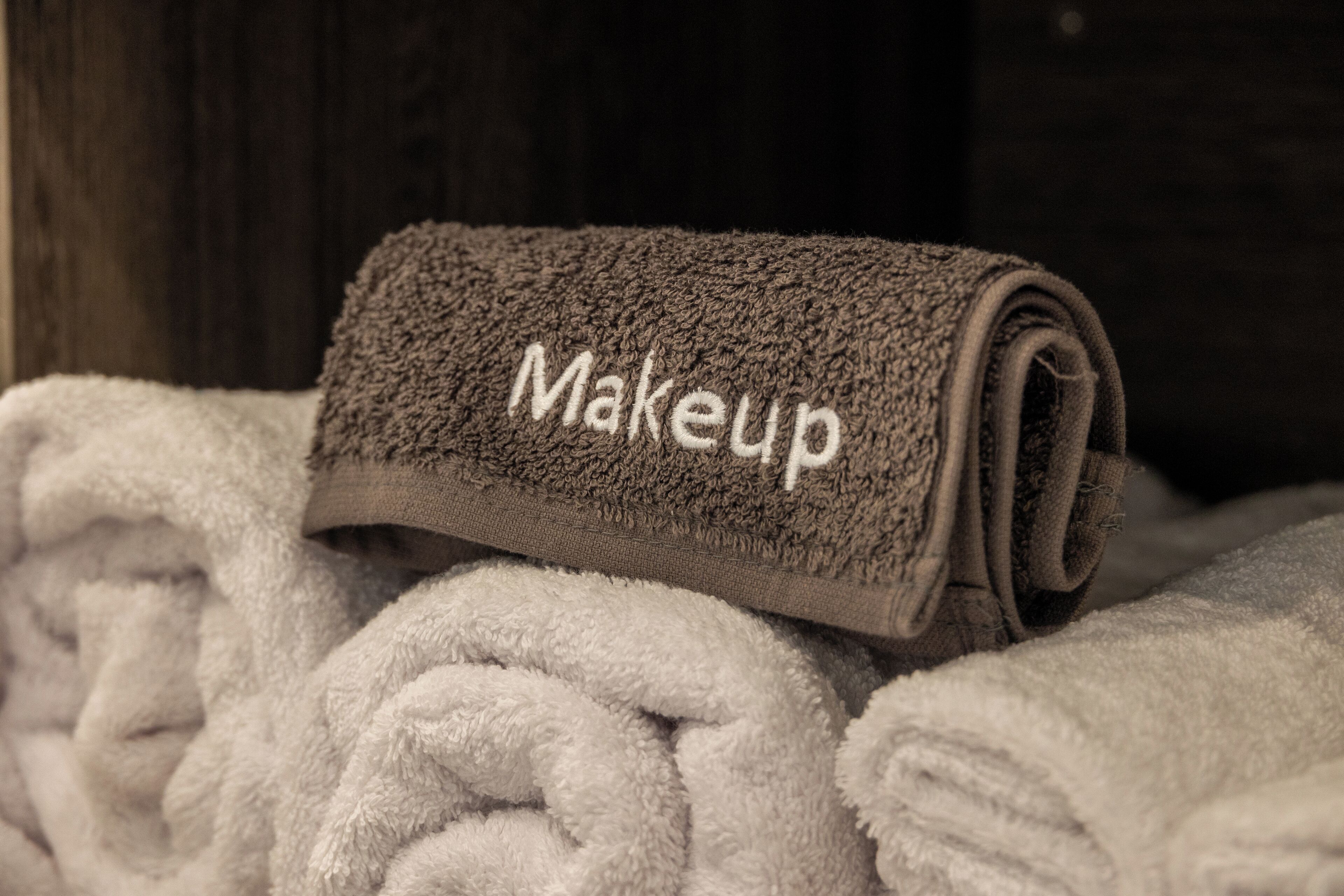Una pila de toallas, una de ellas con la etiqueta 'Makeup'.