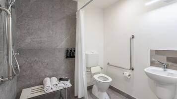 A modern bathroom with a shower, toilet, and sink.