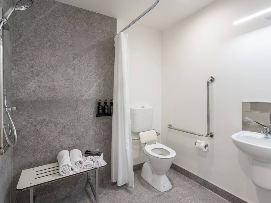 A modern bathroom with a shower, toilet, and sink.
