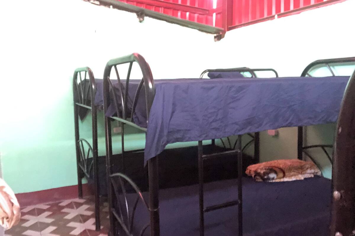 A bunk bed room with a blue mattress and metal railings.