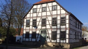 A traditional half-timbered building with a steep gabled roof, multiple windows, and a small front porch. - Majestic Apartment in Brakel (Brakel)