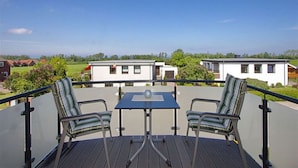 A deck with two chairs and a table, overlooking a row of mobile homes. - Albatros in the House of Aquarius (Rerik)