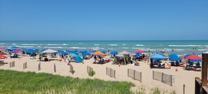 Une plage avec de nombreux parasols et des chaises de plage, ce qui indique qu’il s’agit d’une plage publique.