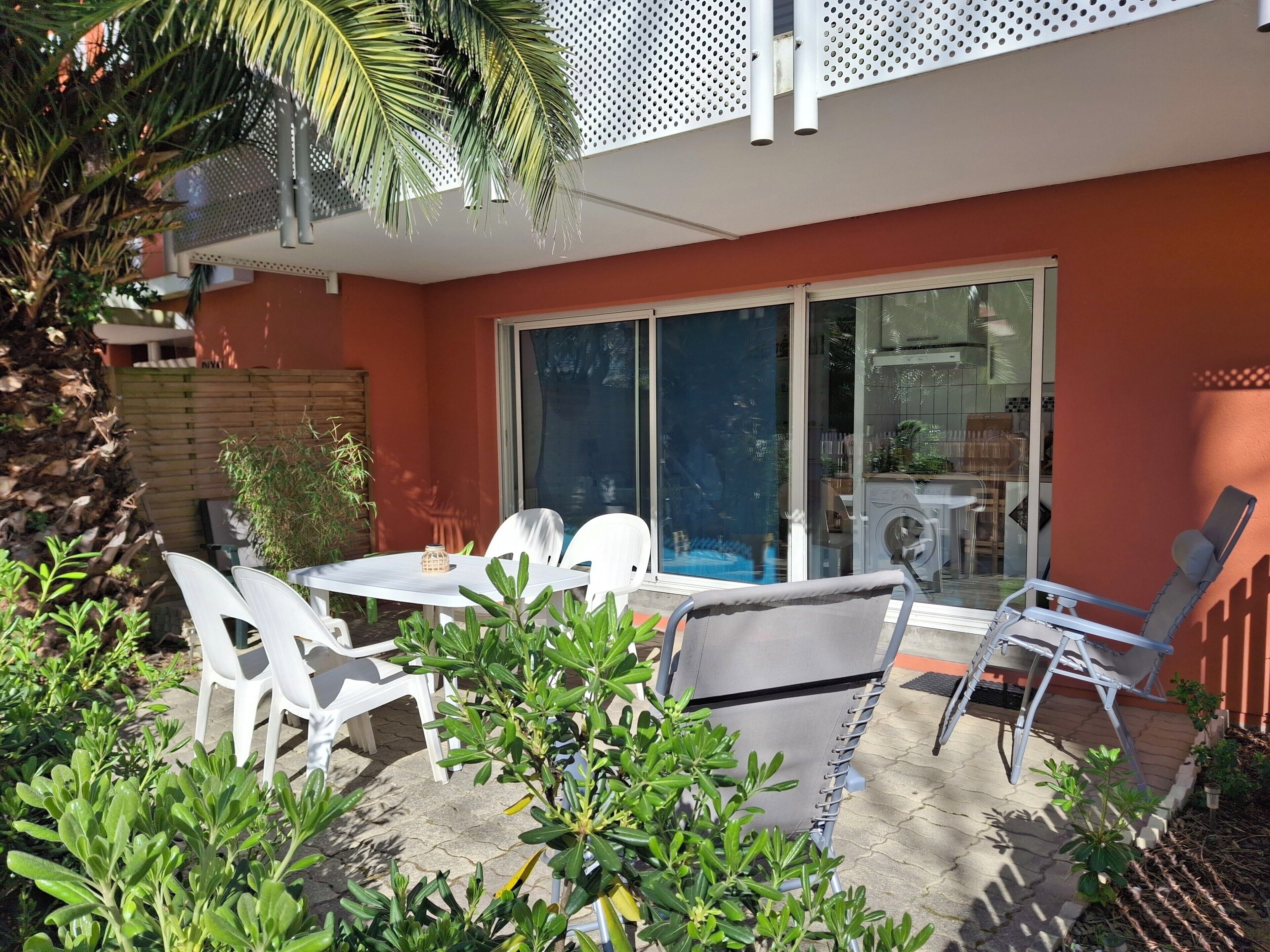 A patio with a table and chairs, a pool, and a laundry area.