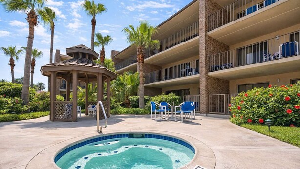 A hotel with a hot tub, outdoor seating, and a covered pavilion. - Padre Oasis #302 (South Padre Island)