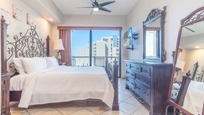 A bedroom with a large bed, a dresser, a mirror, and a ceiling fan. - Las Palomas 3 BR 2 BA Topaz 801 (Puerto Peñasco)