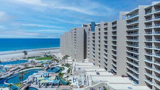 A high-rise hotel with multiple balconies, a pool area, and a beach view. - Las Palomas 3 BR 2 BA Topaz 801 (Puerto Peñasco)