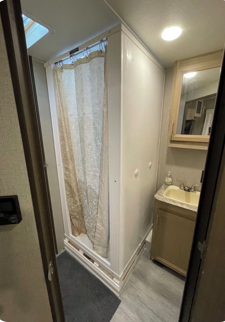 Ein Badezimmer mit Dusche, Waschbecken und Spiegel.