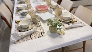 A dining table set with plates, glasses, and a centerpiece. - Casa de Luxo, com Piscina na Penha, ZL. Aceita day use até 30 Pessoas (Jardim Popular São Paulo)