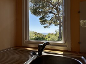 Bathroom with a serene view of a tree and body of water.