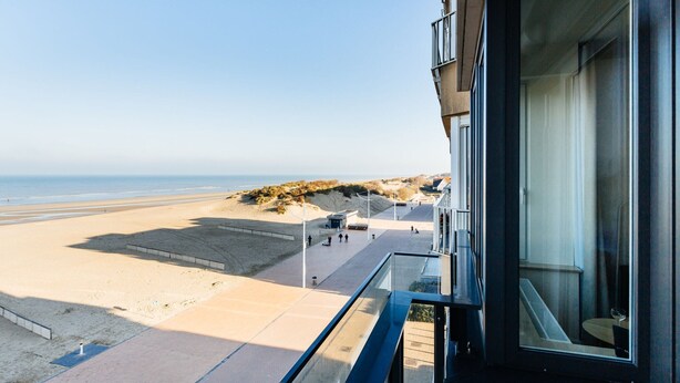 Un immeuble moderne doté d’un balcon donnant sur une plage.