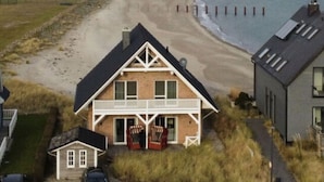 A coastal house with a balcony, a view of the beach, and a lighthouse in the distance. - Holiday Home on the Baltic Sea (Kappeln)