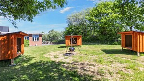 A backyard with two wooden sheds, a brick building, and a lawn. - 12 Person Holiday Home in Roslev (Roslev)