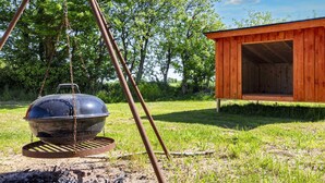 A barbecue grill outdoors with a wooden structure nearby. - 12 Person Holiday Home in Roslev (Roslev)