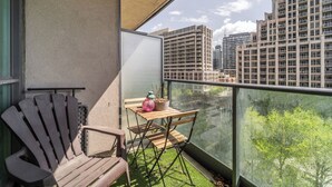 A balcony with a wooden chair, a small table, and a potted plant. - Spacious 3bed/2 bath Downtown Toronto condo + Free Parking, min to CN tower (Toronto)