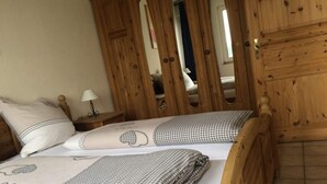 A wooden bed with checkered bedding and a nightstand with a lamp. - 5 Rheinblick Modern Retreat (Linz am Rhein)