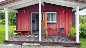 A small red wooden cabin with a porch, a door, and a window. - 2 Person Holiday Home in Kil (Kil)