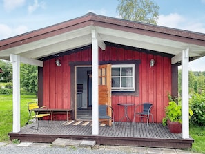 A small red wooden cabin with a porch, a door, and a window. - 2 Person Holiday Home in Kil (Kil)