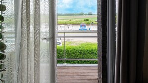 Ein Balkon mit Blick auf einen Kanal, Boote und viel Grün.