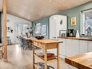 A modern kitchen with a wooden table, white cabinets, and a built-in oven.