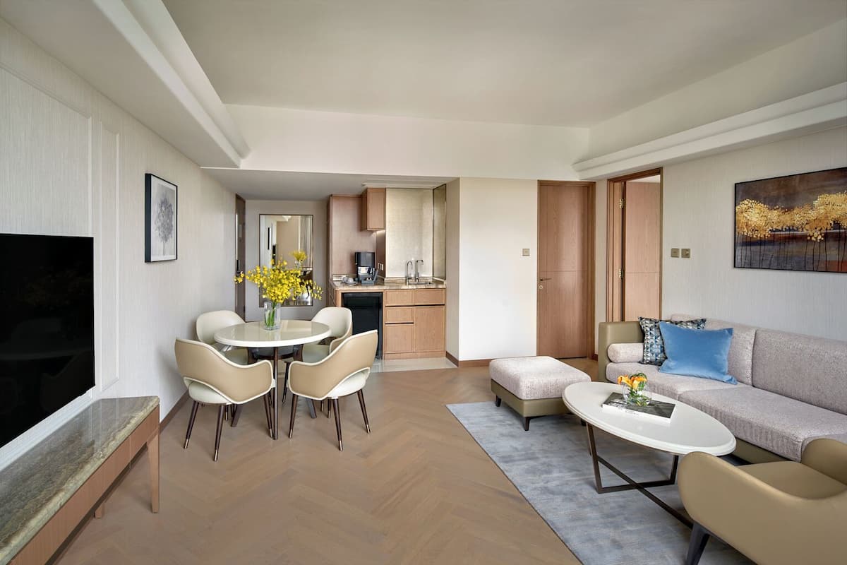 A modern living room with a dining area, a kitchen, and a sofa set.