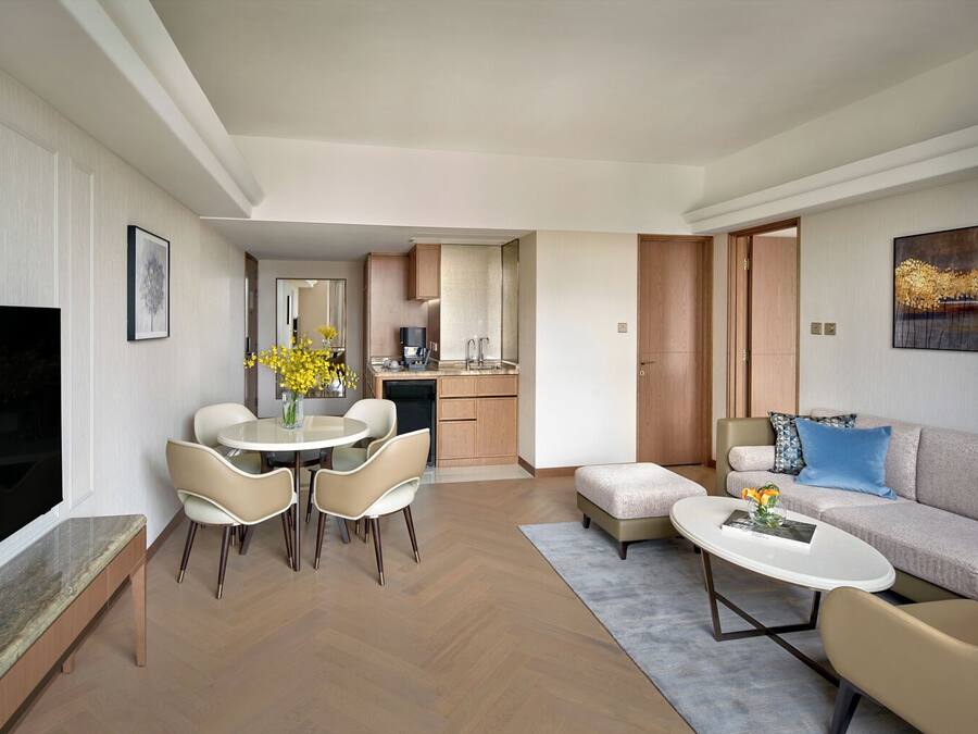 A modern living room with a dining area, a kitchen, and a sofa set.